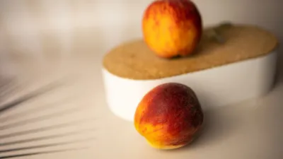 Pêssegos maduros em close sob luz suave, uma referência discreta e sem tabu ao tema do sexo anal